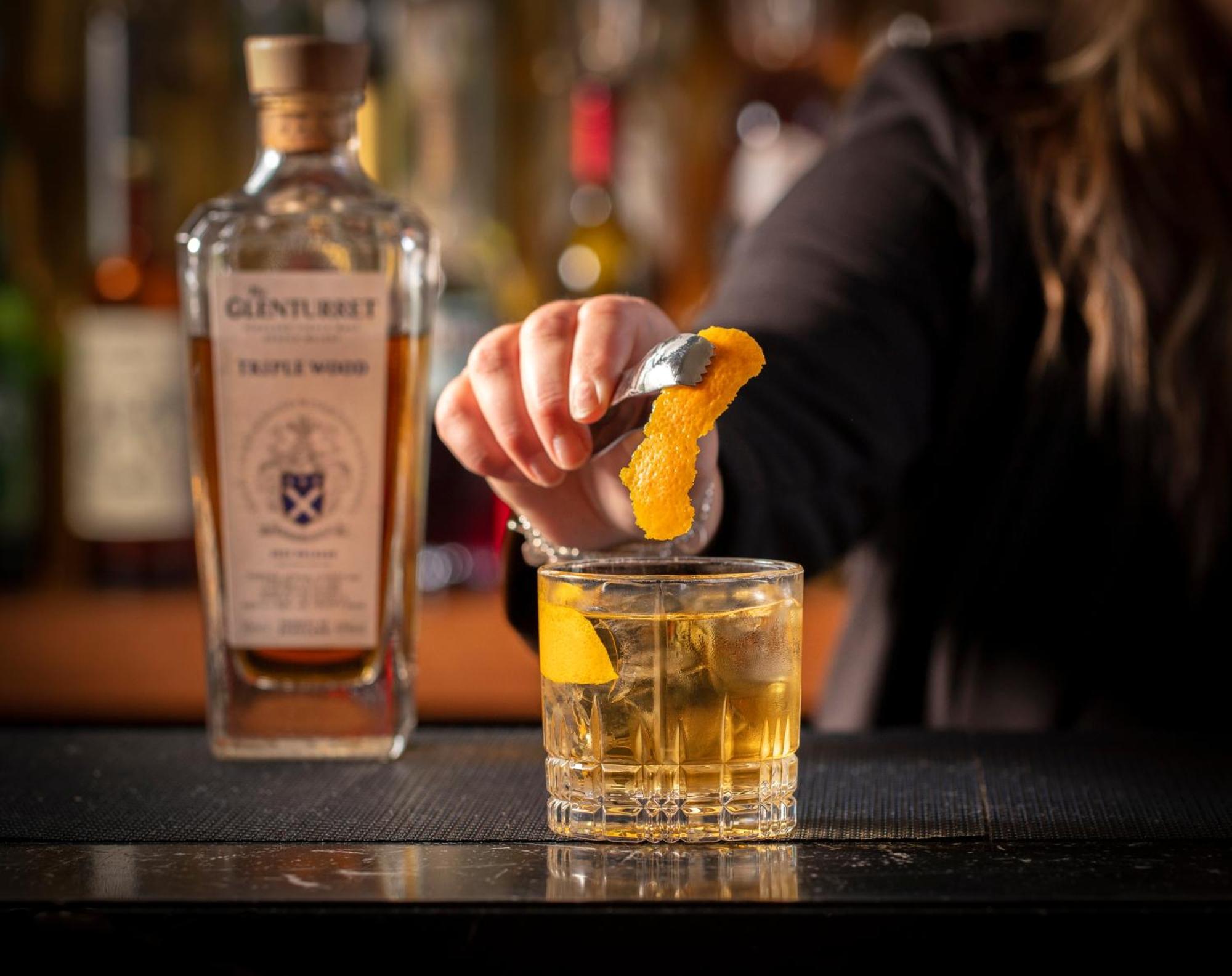 Schloss Roxburghe, Part Of Destination By Hyatt Luaran gambar A bartender adding a lemon twist to a glass of GINfinity